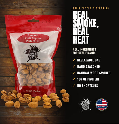 A 12 oz resealable bag of Chili Pepper Pistachios on a dark wood background with scattered pistachios in front. The packaging is red, white, and clear, showing the nuts inside.