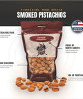 A 12 oz bag of smoked pistachios centered on a white and black marketing graphic with callout text and a 'Made in USA' badge. The package is dark red and clear, showing tan pistachios inside, with additional pistachios scattered around the bag.